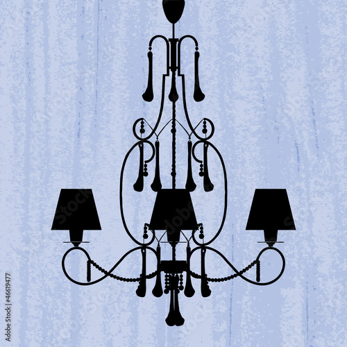 silhouette of luxury chandelier on a scratched blue wallpaper