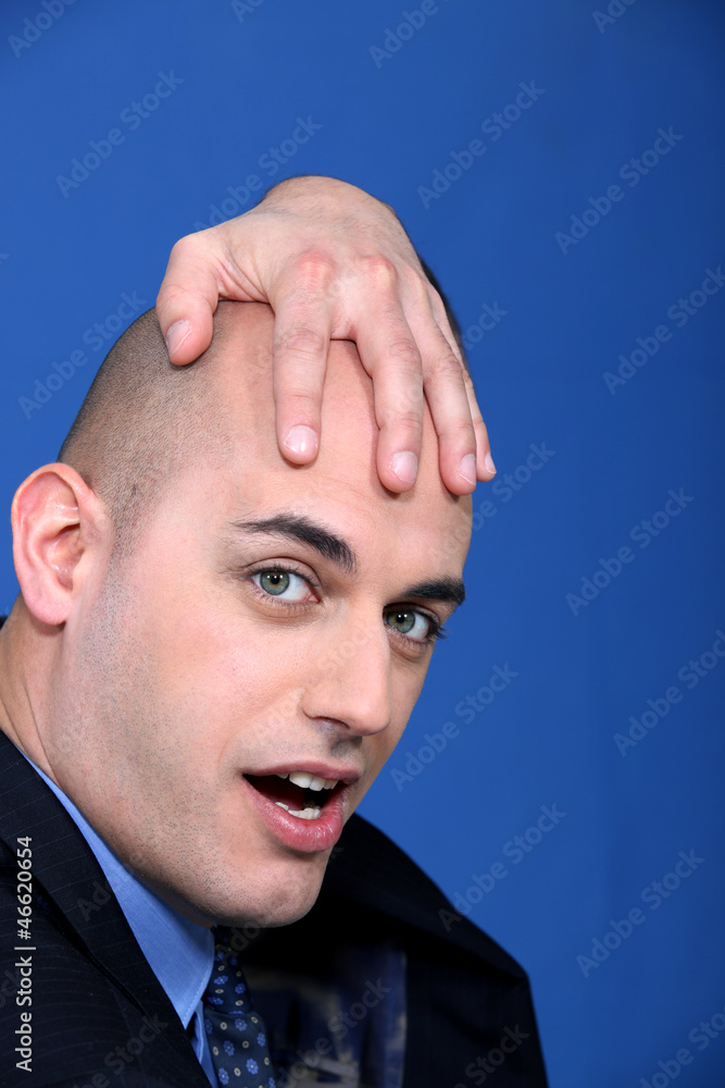 Obraz premium Bald businessman holding his head