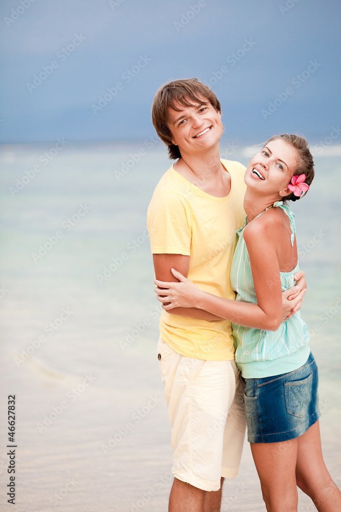 young happy couple having fun om tropical beach. honeymoon