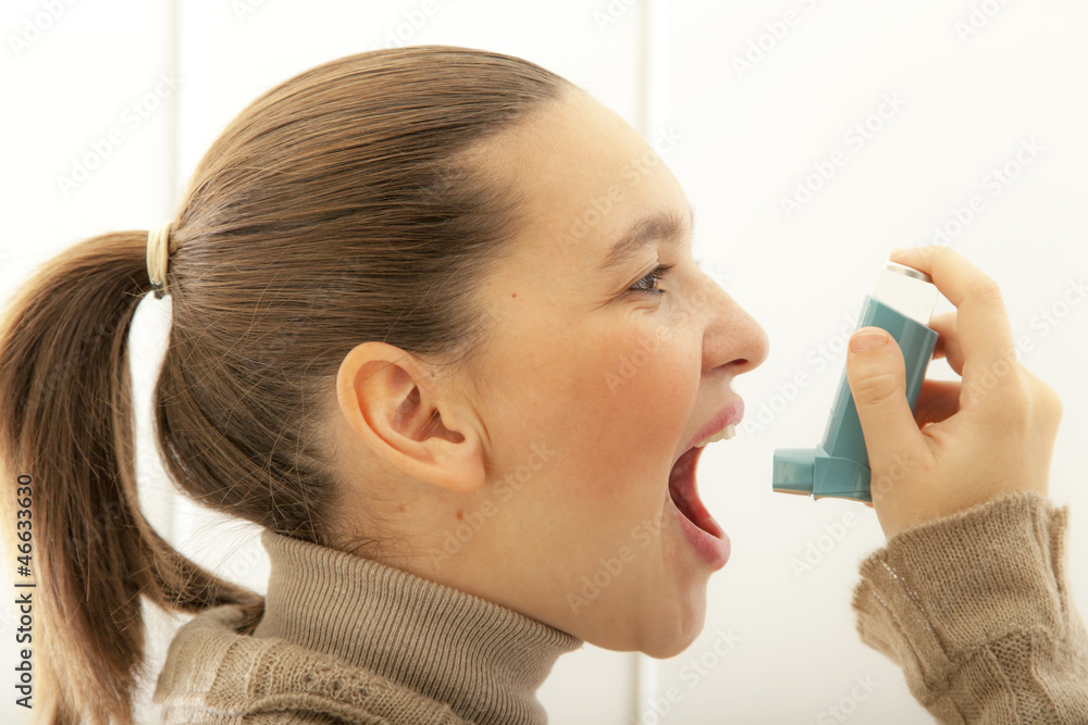 Cute young female start using an asthma inhaler Cute young female start using an asthma inhaler