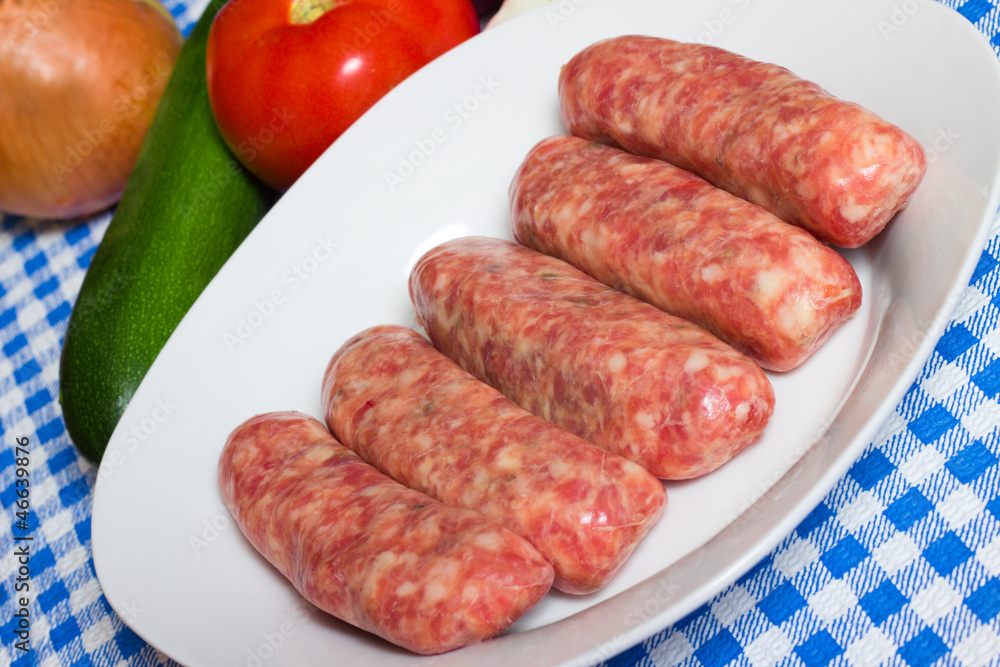 Uncooked sweet Italian sausage on a plate ready to be cooked Uncooked sweet Italian sausage on a plate ready to be cooked