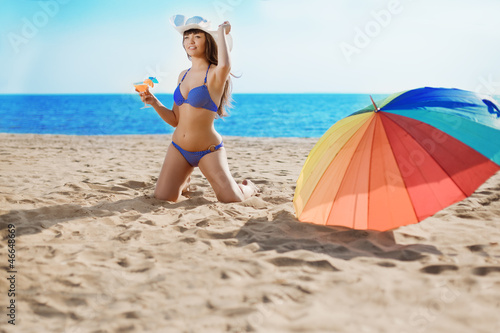 Beautiful woman with a drink in hand on the beach