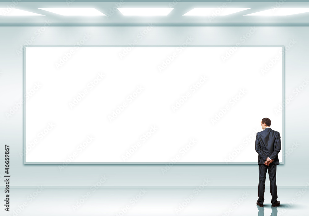 Business person standing near a blank billboard Business person standing near a blank billboard