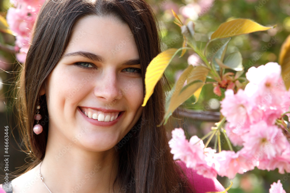 Beautiful happy young woman nearJapanese cherry tree Beautiful happy young woman nearJapanese cherry tree