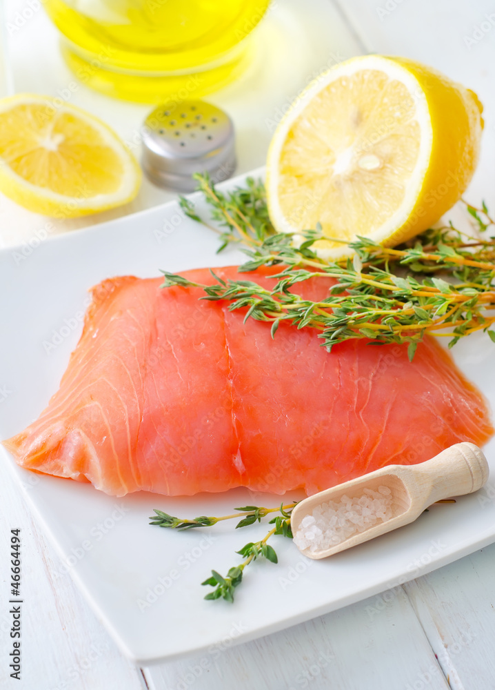 Raw salmon on the white plate with thyme and salt