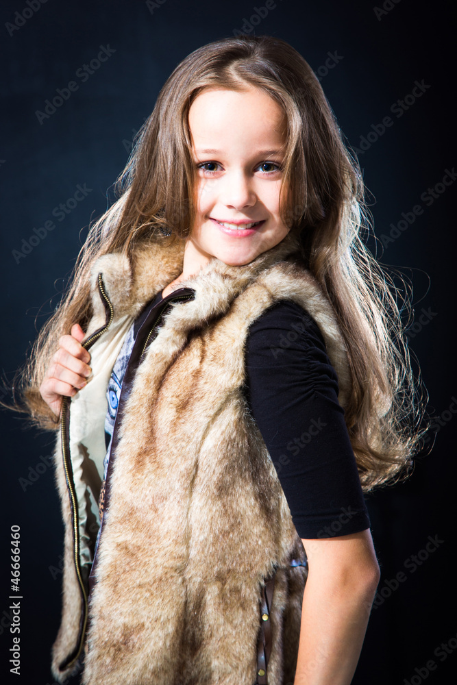 girl with fair long hair in fur vest on dark background girl with fair long hair in fur vest on dark background