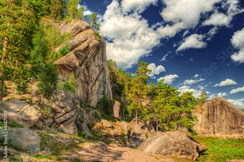 The HDR image of rocks with pain forest and blue sky.