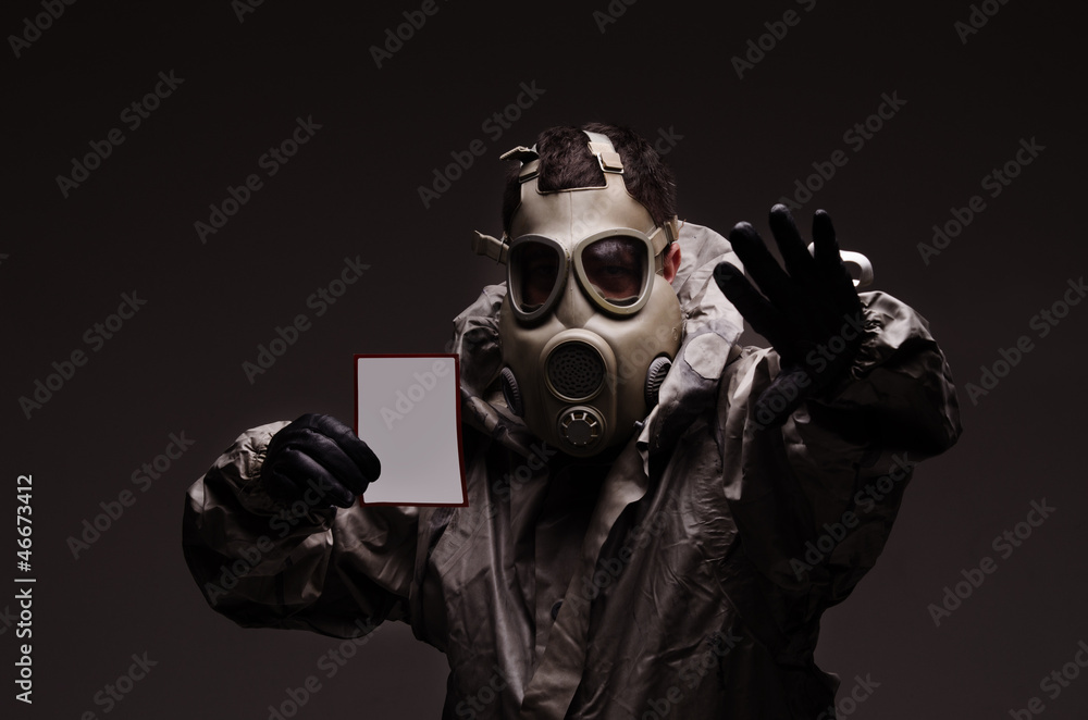 Man with a gas mask wearing hazmat suit, holding