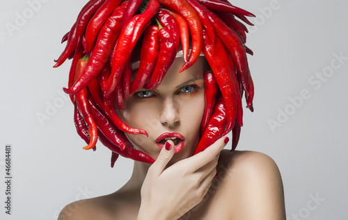 Fashion trendy woman with red chili pepper as a headwear