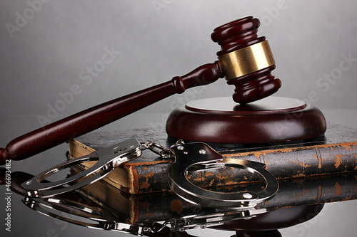 Gavel, handcuffs and.book on law on grey background