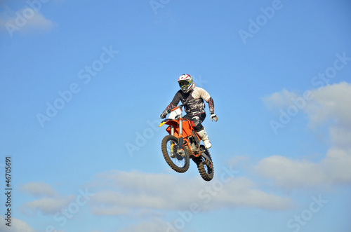 Motocross rider in the air, one-hand operation