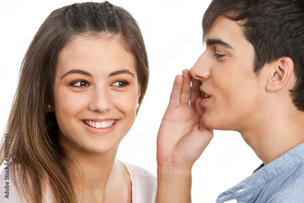 Boy whispering in cute girls ear. Boy whispering in cute girls ear.