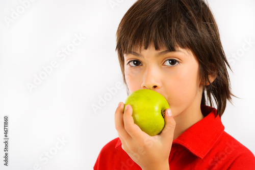 boy eating a green apple isolated on white background
