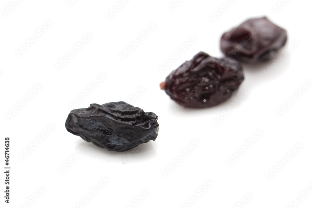 black raisins on a white background black raisins on a white background