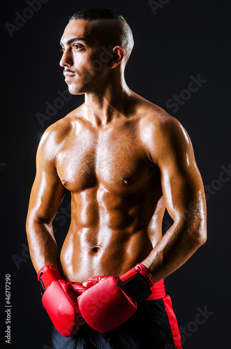 Boxer with red gloves in dark room © Elnur