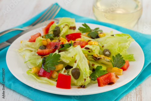 salad on the white plate with glass of wine