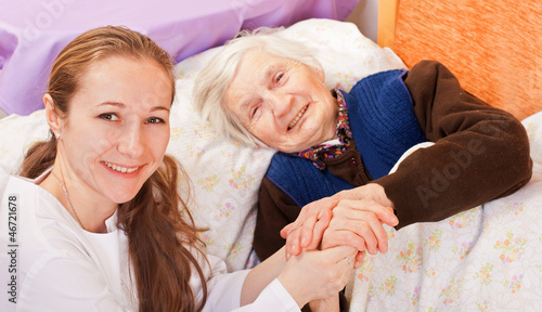 Young doctor holds the elderly woman hands photo