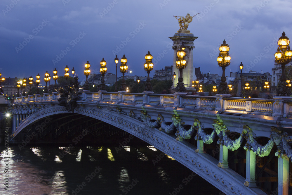 Alexander the Third bridge and Seine under shining lamps at nigh