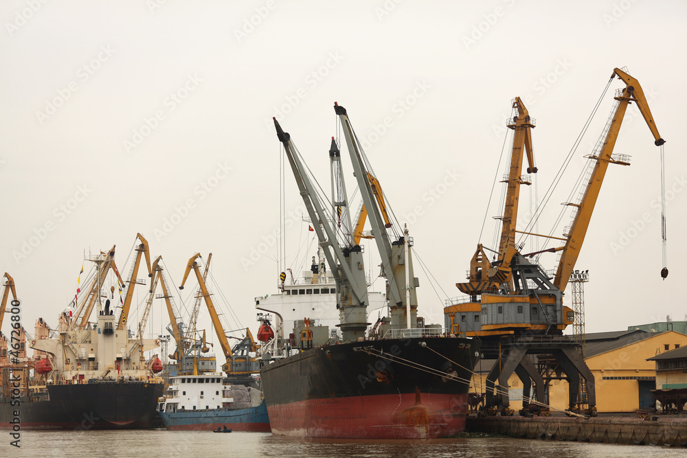 Port or commercial harbor with cargo ship and cranes