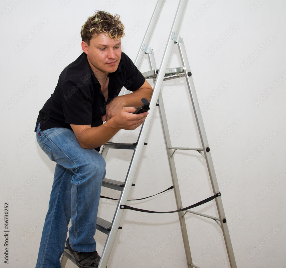 a man with a cell on a stepladder on a white background a man with a cell on a stepladder on a white background