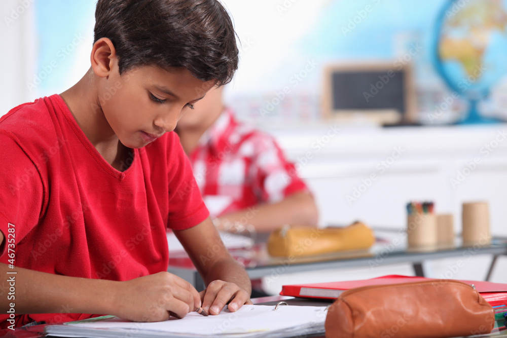 little boy focusing on his work in classroom little boy focusing on his work in classroom