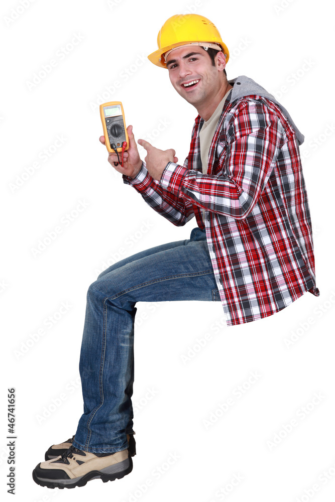 young handsome electrician pointing at tester young handsome electrician pointing at tester