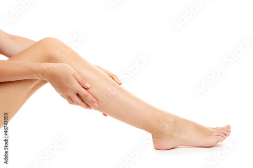 woman holding sore leg  isolated on white