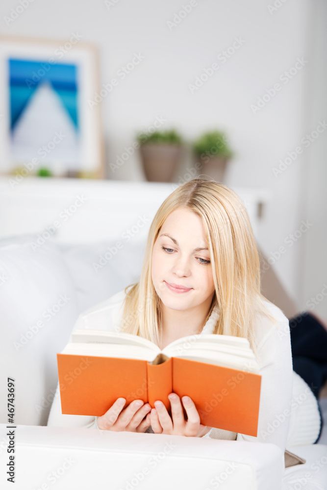 frau liest ein buch auf dem sofa frau liest ein buch auf dem sofa