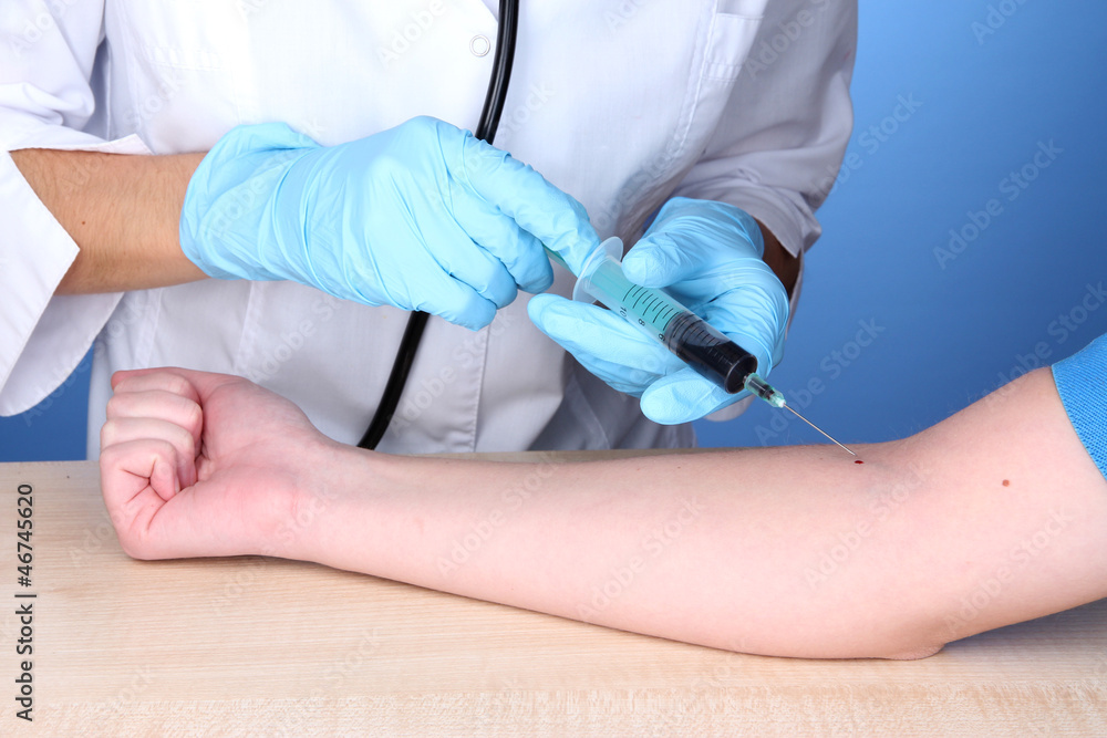 Nurse takes blood from the veins on blue background Nurse takes blood from the veins on blue background