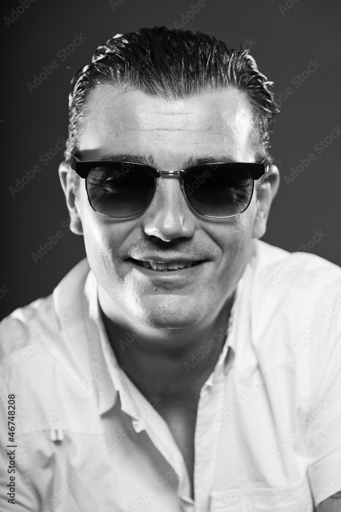 Obraz premium Macho man with short brown hair wearing sunglasses.