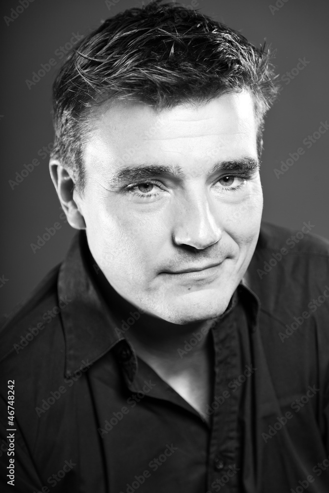 Obraz premium Handsome man with short brown hair. Black and white studio.