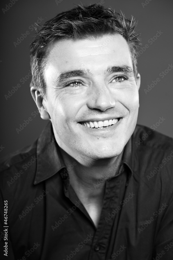 Obraz premium Handsome man with short brown hair. Black and white studio.