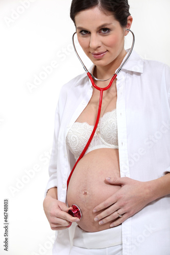 Pregnant woman listening to her baby's heartbeat photo