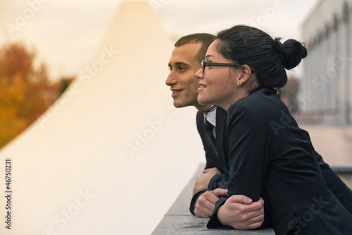 Couple of businessman and woman looking forward outdoors. photo