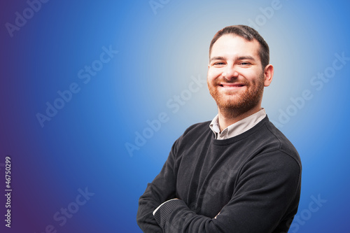 Young man smiling against blue background.