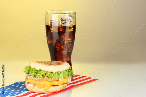tasty sandwich and cola with american flag, on yellow