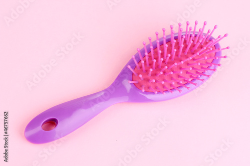 purple hair brush on pink background