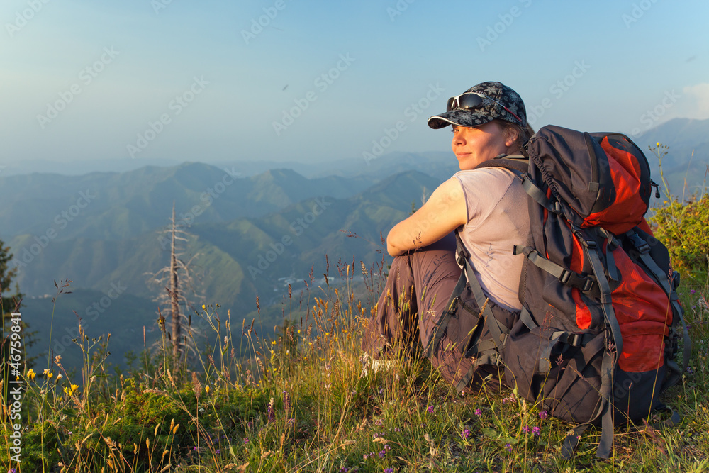 young woman in the mountains at sunset