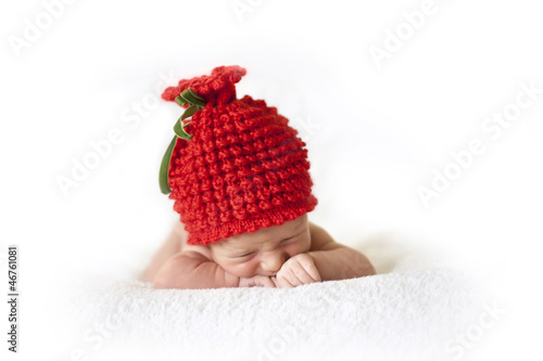 Fototapeta Naklejka Na Ścianę i Meble -  cute newborn baby in a red berry cap on white background