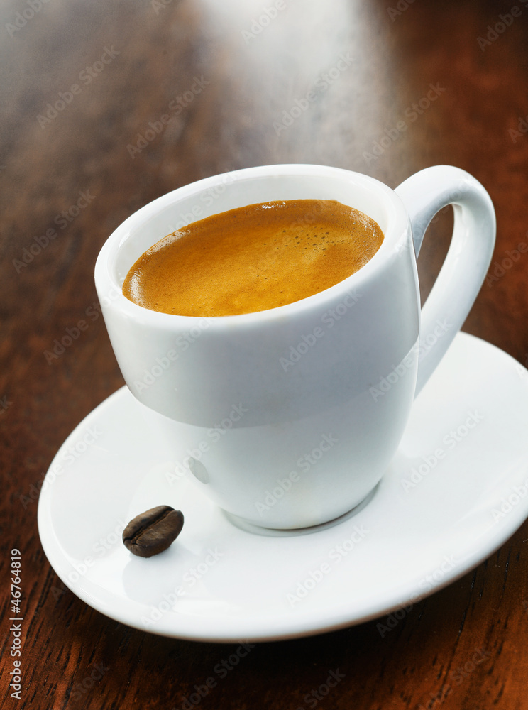 White coffee cup and saucer with single bean White coffee cup and saucer with single bean