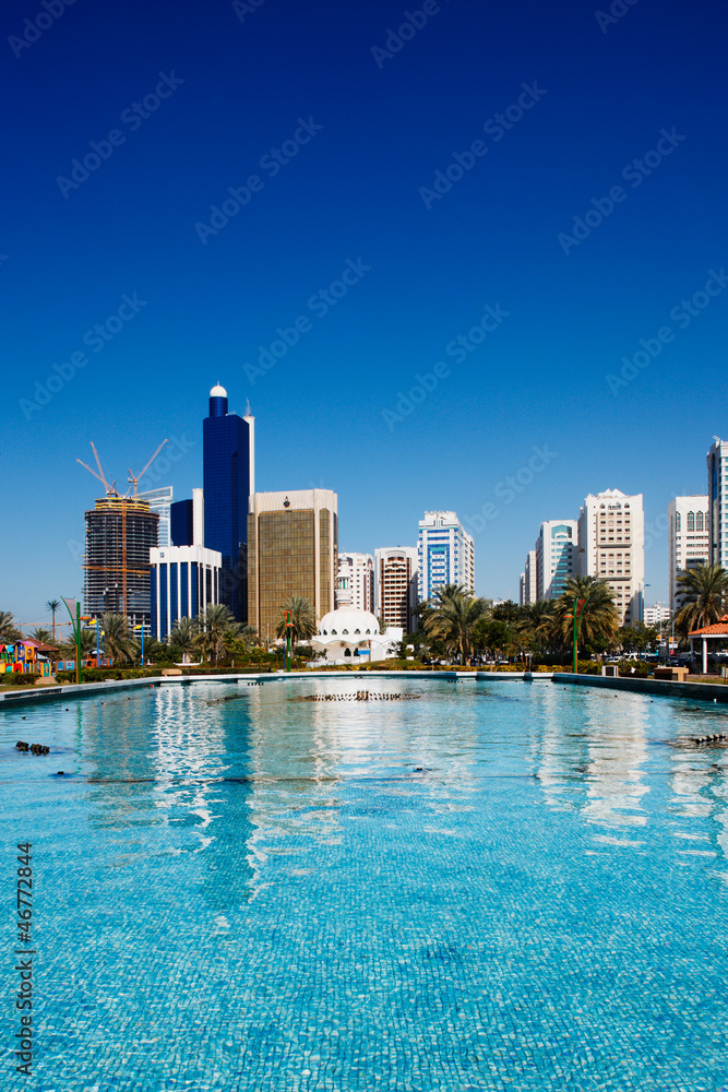 Naklejka premium Panoramę Abu Zabi odbija się od fontanny Corniche