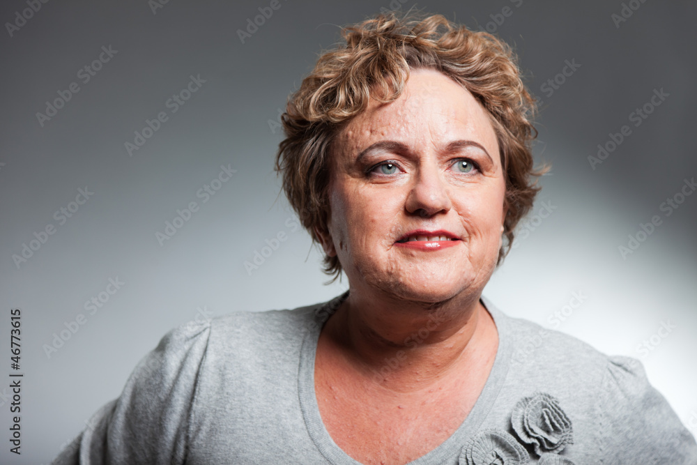 Smiling senior woman with short curly hair. Studio shot. Smiling senior woman with short curly hair. Studio shot.