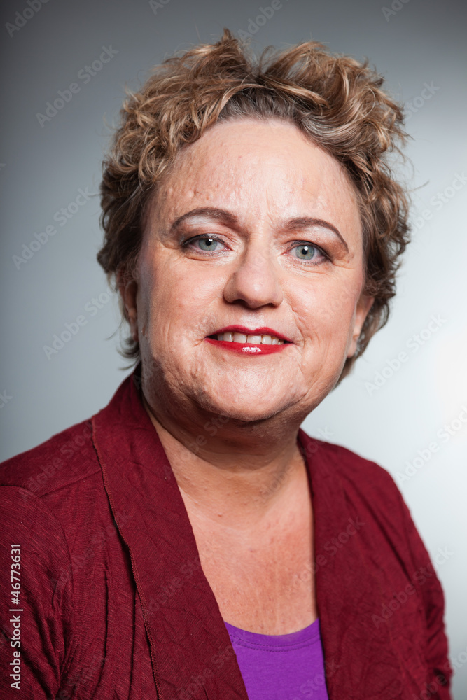 Smiling senior woman with short curly hair. Studio shot. Smiling senior woman with short curly hair. Studio shot.