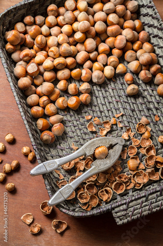 Hazelnuts with nutcracker and nutshel in old basket