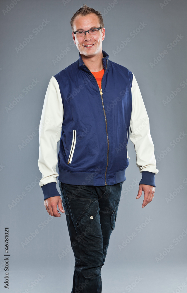 Fototapeta premium Urban fashion man with short hair wearing blue jacket and jeans.