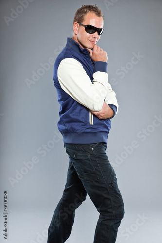 Urban fashion man wearing blue jacket and black sunglasses. © ysbrandcosijn