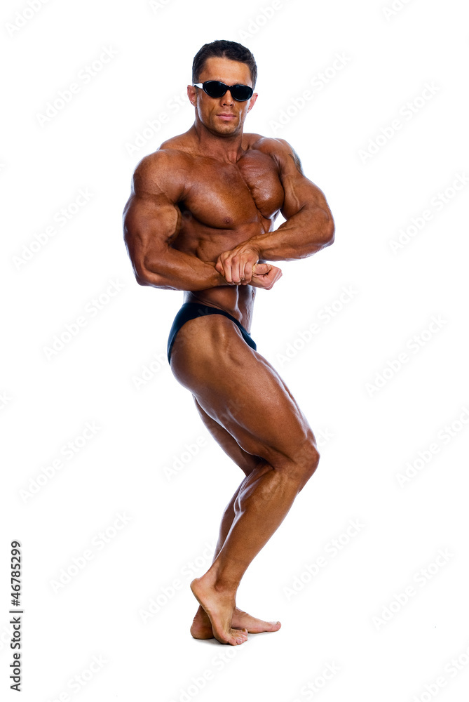 Muscled male model in glasses posing in studio