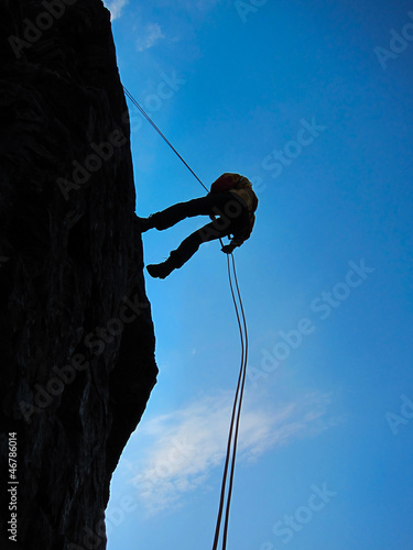 Photography Rock climber silhouetted as abseiling room for copy