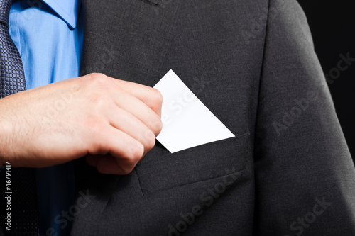 Business man puts a business card in the poket photo