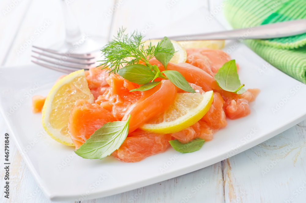 fresh salmon with lemon on the white plate fresh salmon with lemon on the white plate